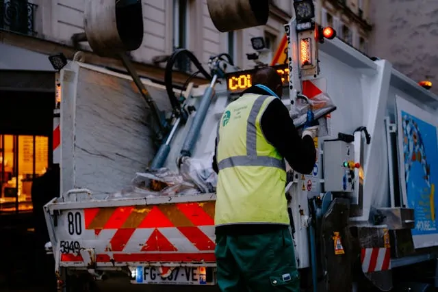 a man collect waste in a large container